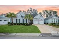 Charming home with a well-manicured lawn, palm trees, and a two-car garage at 332 Fish Creek Ct, Summerville, SC 29486