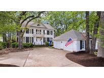 Beautiful two-story home with white siding, black shutters, and a large front yard with mature trees and a detached two-car garage at 3424 Henrietta Hartford Rd, Mount Pleasant, SC 29466
