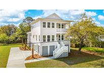 Stunning two-story home featuring a light exterior, double porches, manicured landscaping, and a private driveway at 3683 Nassas St, Mount Pleasant, SC 29466