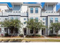 Modern townhome exterior with light gray siding, large windows, and decorative trees enhancing curb appeal at 4577 Summey St, North Charleston, SC 29405