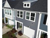 View of the townhome exterior with gray siding, white trim, and a one-car garage at 484 Trotters Ln, Moncks Corner, SC 29461