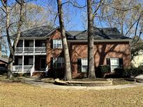 Charming two-story brick home featuring a double porch and mature trees accenting the front yard at 5496 Clearview Dr, North Charleston, SC 29420