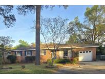 Charming single-story brick home featuring a well-manicured lawn and attached garage at 5937 Willard Dr, Hanahan, SC 29410