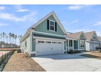 Charming coastal home featuring a two-car garage and light blue siding at 701 Maynard Ln, Summerville, SC 29486