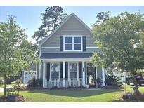 Charming two-story home featuring a classic design and a well-maintained lawn and mature trees at 7406 Purser Ln, Hanahan, SC 29410