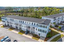 Charming townhome exterior showcasing the covered garages and stacked balconies, perfect for enjoying the outdoors at 806 Kings Oak Court Ct # 7, Charleston, SC 29492