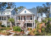 Charming two-story home with a covered front porch and landscaped yard, perfect for relaxing or entertaining at 8067 Jack Island Dr, Johns Island, SC 29455