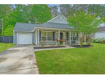 Charming single-story home with a well-manicured lawn, flowering bushes and an attached garage at 9156 Fieldstone Trce, Summerville, SC 29485