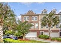 Charming townhome exterior with well-manicured landscaping, garage, and palm trees at 9316 Sweetbay Ct, Ladson, SC 29456