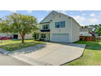 Charming two-story home with white siding, turquoise shutters, and a well-manicured lawn at 1005 Golden Aspen Dr, Moncks Corner, SC 29461