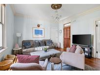 Bright living room featuring stylish furnishings, hardwood floors, and elegant lighting fixture at 162 Spring St # A, Charleston, SC 29403