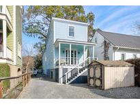 Charming light blue two-story home with inviting front porch and well-maintained yard and gravel drive at 162 Spring St # D, Charleston, SC 29403