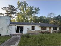 Modest ranch-style home with a partially overgrown yard and cinderblock construction at 1633 Southwick Dr, Johns Island, SC 29455