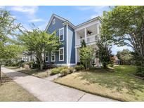 Charming two-story blue home featuring a welcoming front porch and well-manicured landscaping at 1814 Grovehurst Dr, Charleston, SC 29414