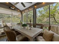 Inviting screened porch with a wooden table, wicker chairs, and tranquil views at 2401 Racquet Club Dr, Seabrook Island, SC 29455