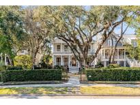 Beautiful two-story home showcasing mature landscaping, a gated entrance, and a charming front porch at 251 Delahow St, Charleston, SC 29492