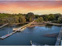 Expansive waterfront property with a private dock, lush trees, and a beautiful sunset view at 3610 Legareville Rd, Johns Island, SC 29455
