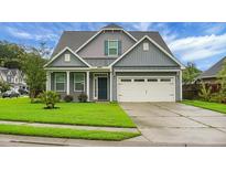 Charming home featuring a well-maintained lawn, two-car garage, and attractive exterior finishes at 504 Foxbank Plantation Blvd, Moncks Corner, SC 29461
