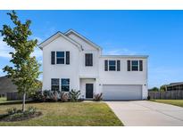 Charming two-story home with white siding, a two-car garage, and a well-manicured front lawn at 715 Mcroy St, Moncks Corner, SC 29461