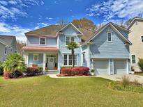 Charming two-story home with light blue siding, a well-manicured lawn, and a welcoming front porch at 855 Hunt Club Run, Charleston, SC 29414