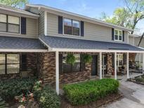 Charming townhome featuring a brick facade, covered porch, manicured landscaping and classic shutters at 880 Simpkins St # 2, Charleston, SC 29412
