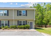 A charming townhouse with olive green siding, black shutters, and a well-maintained front lawn at 1086 Lexi Ct, Ladson, SC 29456