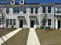 View of townhomes with individual walkways, dark front doors, and neatly landscaped yards at 123 Brown Swiss Cir, Summerville, SC 29483