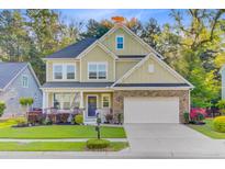 Charming two-story home featuring a well-manicured lawn and welcoming front porch at 132 Daniels Ridge Dr, Summerville, SC 29485