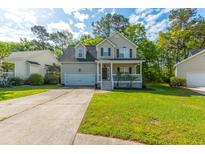 Charming two-story home with a front porch, garage, and well-maintained lawn in a sunny neighborhood at 133 Hanahan Plantation Cir, Hanahan, SC 29410