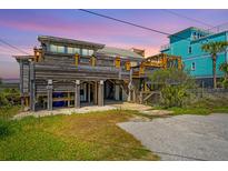 Charming coastal home with elevated construction, offering a unique design and marsh view at sunset at 1604 E Ashley Ave, Folly Beach, SC 29439