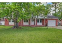 Charming brick home featuring a well-manicured lawn and mature tree with spanish moss at 201 Judith Dr, Summerville, SC 29485