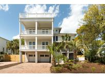 Stunning three-story home features multiple balconies, two-car garage, and beautiful brick driveway at 3007 Cameron Blvd, Isle of Palms, SC 29451