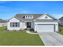 Charming single-story home features a manicured lawn, two-car garage, and classic white siding at 308 Cypress Branch Rd, Huger, SC 29450