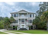 Charming two-story home featuring a symmetrical facade, dual balconies, and a well-manicured lawn at 3547 Holmgren St, Mount Pleasant, SC 29466