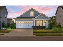 Charming single-Gathering home with a well-manicured lawn and a two-car garage at dusk at 411 Freeland Way, Moncks Corner, SC 29461