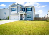Two-story home featuring light gray siding, black shutters, a well-manicured lawn, and a two-car garage at 613 Ravens Wood Rd, Summerville, SC 29486