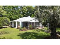 Charming home with screened porch, lush landscaping, and a beautiful lawn at 104 Waccamaw Dr, Summerville, SC 29485
