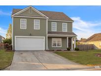 Charming two-story home with a well-maintained lawn and attached two-car garage for ample parking at 1097 Briar Rose Ln, Ladson, SC 29456