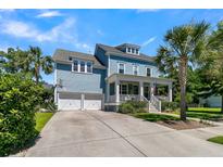 Charming two-story blue home features a welcoming front porch, palm trees, and a two-car garage at 1325 Whisker Pole Ln, Mount Pleasant, SC 29466
