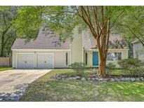 Charming home featuring an attached two-car garage, complemented by a blue front door and a well-maintained front yard at 141 Bridgecreek Dr, Goose Creek, SC 29445