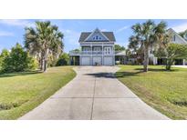 Charming coastal home with a long driveway, three garage doors, and a large balcony at 1595 Teal Marsh Rd, Charleston, SC 29412