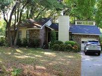 Charming home featuring a brick facade, well-maintained landscaping, and an attached garage at 20 Anderson Ave, Charleston, SC 29412