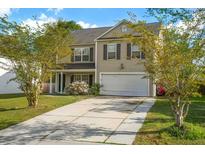 Charming two-story home featuring a manicured lawn, a driveway, and an attached two-car garage at 2007 Robin Wood Blvd, Moncks Corner, SC 29461