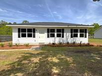 Charming one-story home featuring a well-manicured lawn and a welcoming front entrance at 202 Resinwood Rd, Moncks Corner, SC 29461