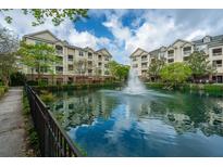 Beautiful community pond with fountain, surrounded by lush greenery and apartments at 2244 Ashley Crossing Drive Dr # 621, Charleston, SC 29414