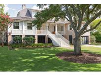 Charming two-story home with landscaped yard, large tree, and elevated front porch at 2407 Atlantic Ave, Sullivans Island, SC 29482