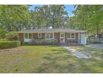 Charming brick home with a well-manicured lawn and mature trees providing ample shade at 2645 Mona Ave, Charleston, SC 29414