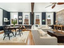 Charming living room featuring hardwood floors, exposed brick, lots of natural light, and stylish decor at 29 1/2 State St # B, Charleston, SC 29401