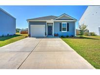 Charming one-story home with a well-manicured lawn and a long concrete driveway leading to an attached garage at 303 Feldspar Ln, Ladson, SC 29456