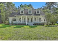 Charming home featuring a welcoming front porch and dormer windows at 5950 Lowell Reed Rd, Ravenel, SC 29470